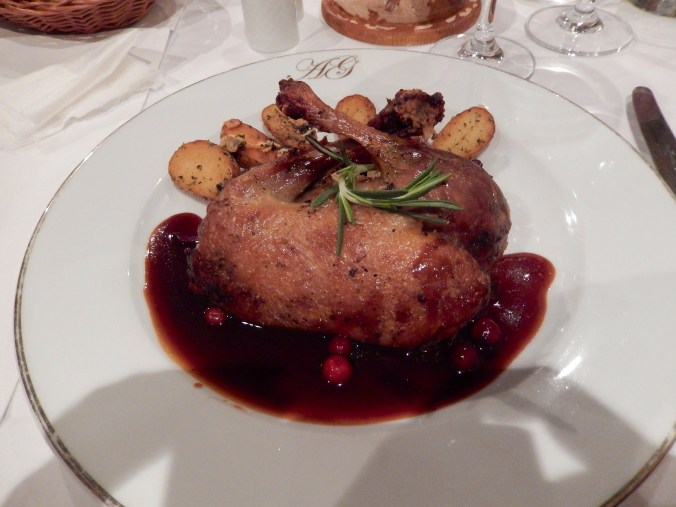 Half a duck, on white and red cabbage and roasted potatoes