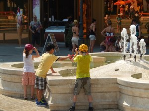These boys were cooling off by filling their caps with water and putting them back on their head