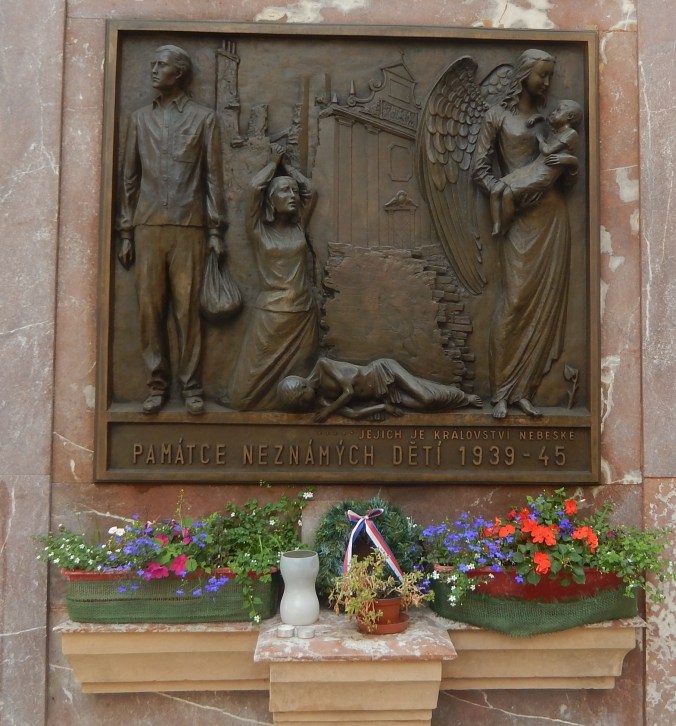 I do not know the significance of this sculpture outside the church.  I will hazard a guess that Carmelite nuns were particularly connected with children, and that this is a memorial to children who suffered in WWII